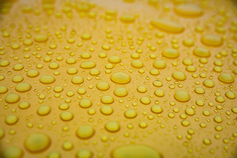 water droplets on top of clean yellow metallic car 