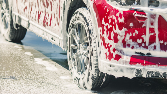 red car covered in car cleaner soap for full exterior valeting
